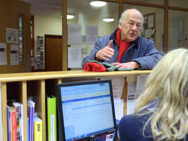 Patient at GP reception desk